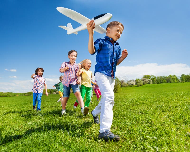 Primo piano dell'aeroplano e dei bambini della tenuta del ragazzo dietro fotografia stock Primo piano dell'aeroplano e dei bambini della tenuta del ragazzo dietro fotografia stock