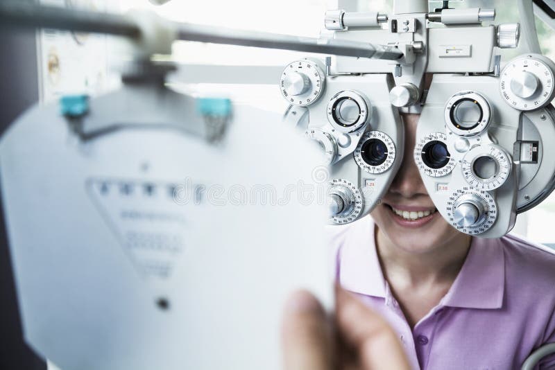 Primo piano dell'optometrista che fa un esame di occhio sulla giovane donna fotografie stock Primo piano dell'optometrista che fa un esame di occhio sulla giovane donna fotografie stock