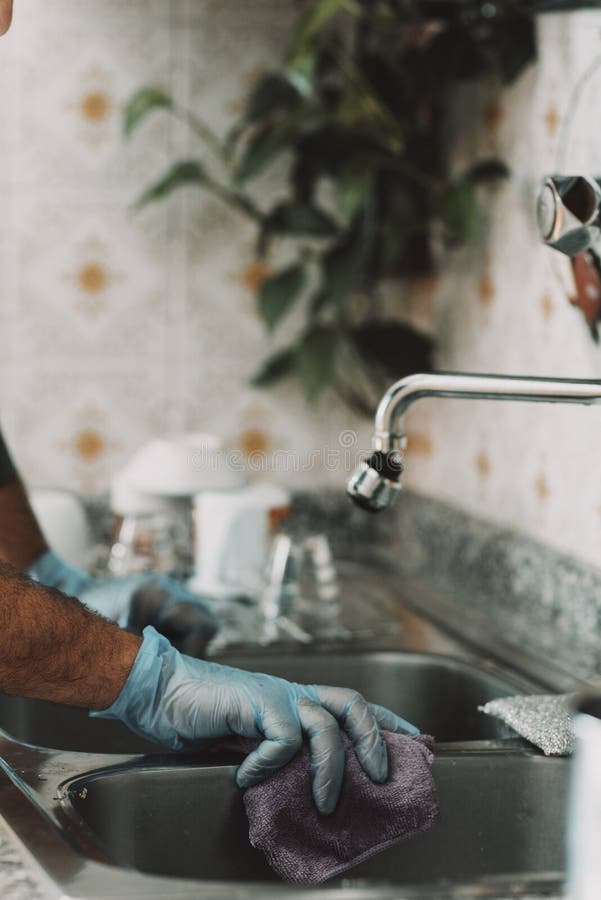 Primo piano dell'uomo a casa che pulisce la cucina dopo aver cucinato e lavato i piatti. uomo solo, stile di vita. marito che fa fotografia stock libera da diritti