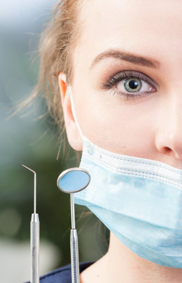 Primo piano della maschera d'uso del mezzo della donna fronte del dentista immagini stock Primo piano della maschera d'uso del mezzo della donna fronte del dentista immagini stock