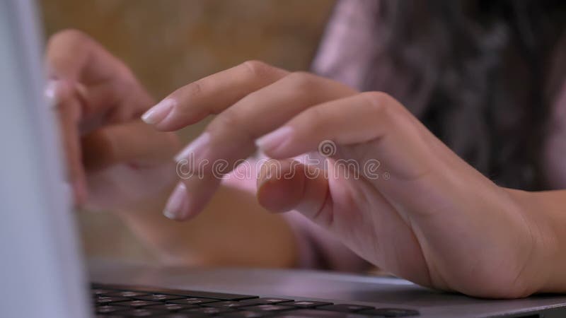 Primo piano delle mani femminili che scrivono su una tastiera, lavorante ad un computer portatile