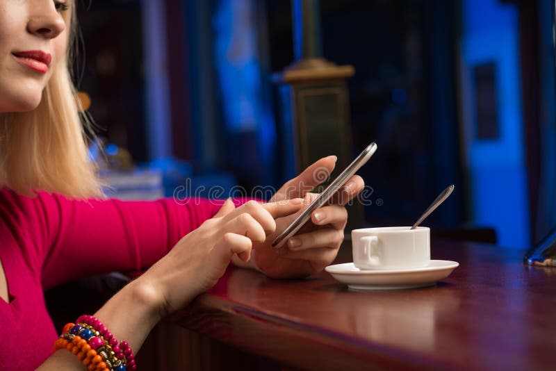 Primo piano delle mani femminili che tengono un telefono cellulare immagini stock libere da diritti Primo piano delle mani femminili che tengono un telefono cellulare immagini stock libere da diritti