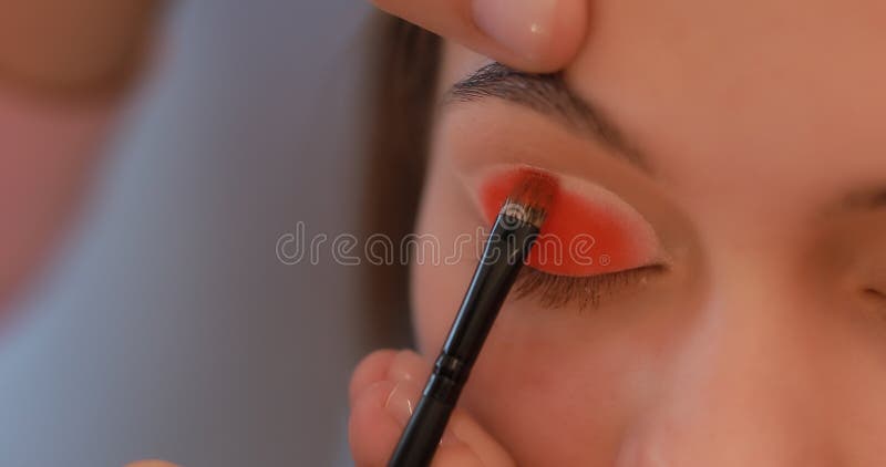 Primo piano delle palpebre della pittura nel colore arancio