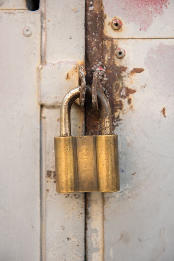 Primo piano delle porte del metallo con oro, vecchia serratura gialla Immagine verticale fotografia stock
