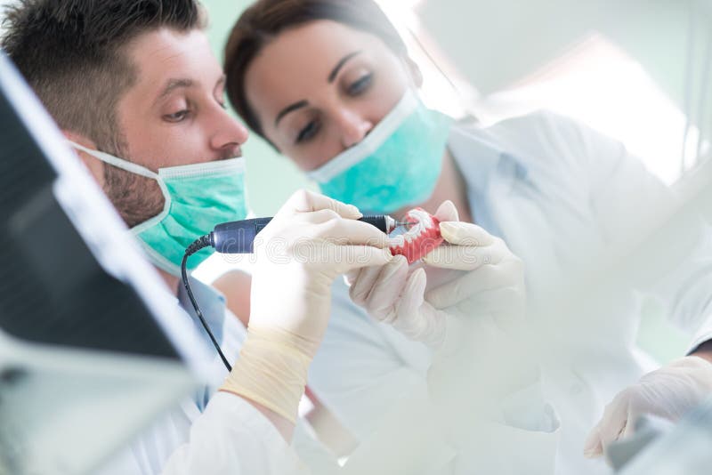 Primo piano dello studente di odontoiatria che pratica su un manichino medico immagini stock Primo piano dello studente di odontoiatria che pratica su un manichino medico immagini stock