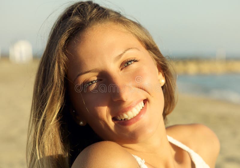 Primo piano di bella giovane donna bionda con gli occhi azzurri che sorride sulla spiaggia fotografie stock libere da diritti Primo piano di bella giovane donna bionda con gli occhi azzurri che sorride sulla spiaggia fotografie stock libere da diritti