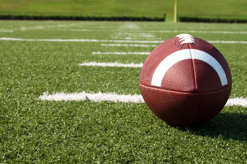 Primo piano di football americano sul campo fotografia stock Primo piano di football americano sul campo fotografia stock
