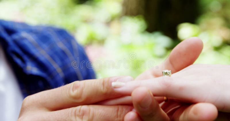 Primo piano di mettere anello di fidanzamento sulla mano della donna