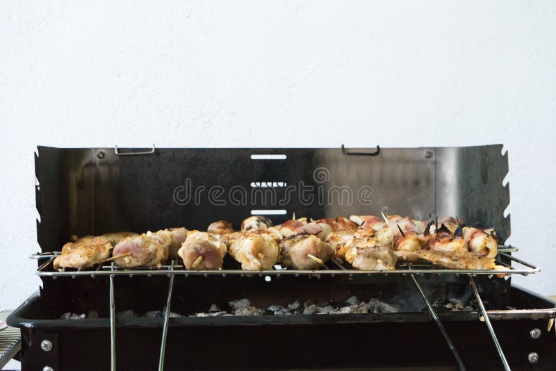 primo piano di una certa carne sugli spiedi di legno che sono grigliati in un barbecue Grigliare shashlik marinato su una griglia immagine stock libera da diritti primo piano di una certa carne sugli spiedi di legno che sono grigliati in un barbecue Grigliare shashlik marinato su una griglia immagine stock libera da diritti