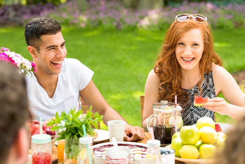 Primo piano di una coppia multiculturale che ride con i loro amici d fotografia stock libera da diritti Primo piano di una coppia multiculturale che ride con i loro amici d fotografia stock libera da diritti