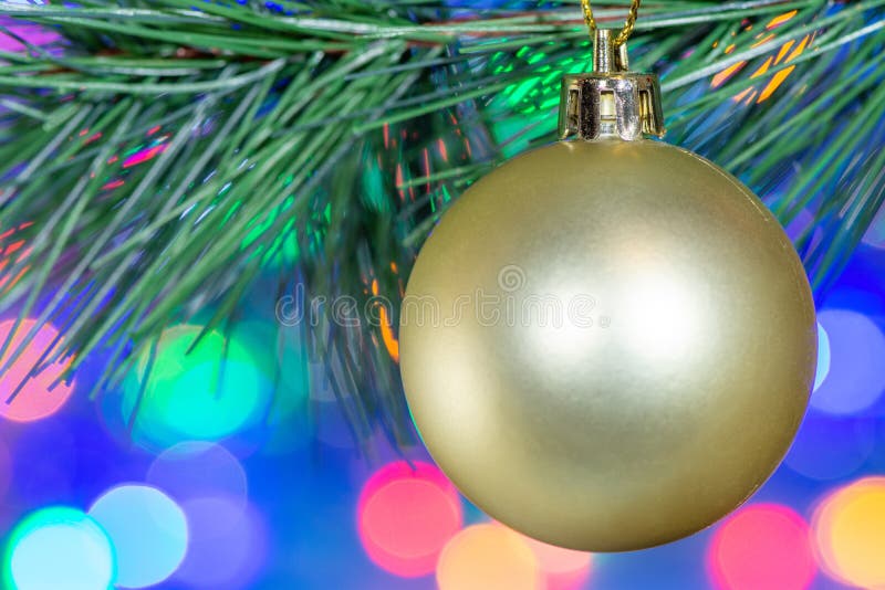 Primo piano di una palla dorata del bello dell'albero di Natale giocattolo della decorazione sui precedenti della ghirlanda confu immagine stock libera da diritti Primo piano di una palla dorata del bello dell'albero di Natale giocattolo della decorazione sui precedenti della ghirlanda confu immagine stock libera da diritti
