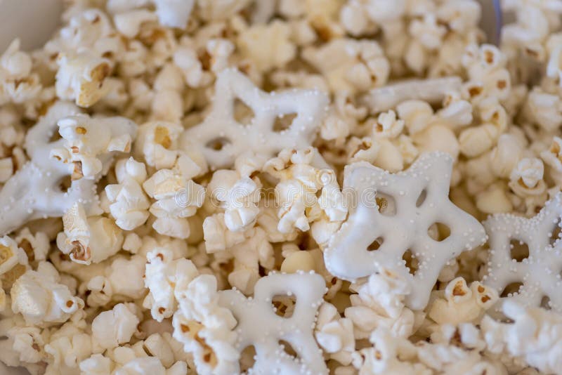 Primo piano sopraelevato di popcorn e delle ciambelline salate in ciotola nel wnter fotografia stock Primo piano sopraelevato di popcorn e delle ciambelline salate in ciotola nel wnter fotografia stock