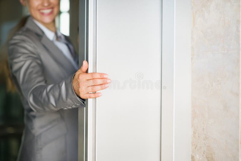 Primo piano sul portello dell'elevatore della holding della mano della donna