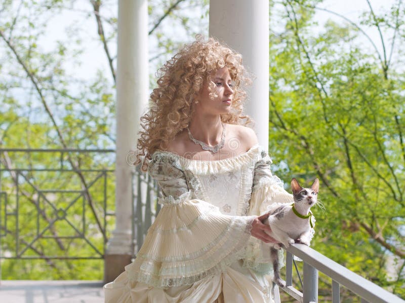 Half-length portrait of beautiful woman in medieval dress with cat on the terrace. Charming elegant european woman stock images, royalty-free photos and pictures