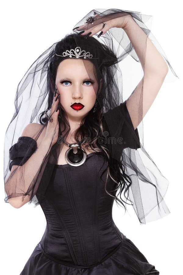 Young beautiful gothic woman in corset dress and black bridal veil over white background. Young beautiful gothic woman in corset dress and black bridal veil over white background
