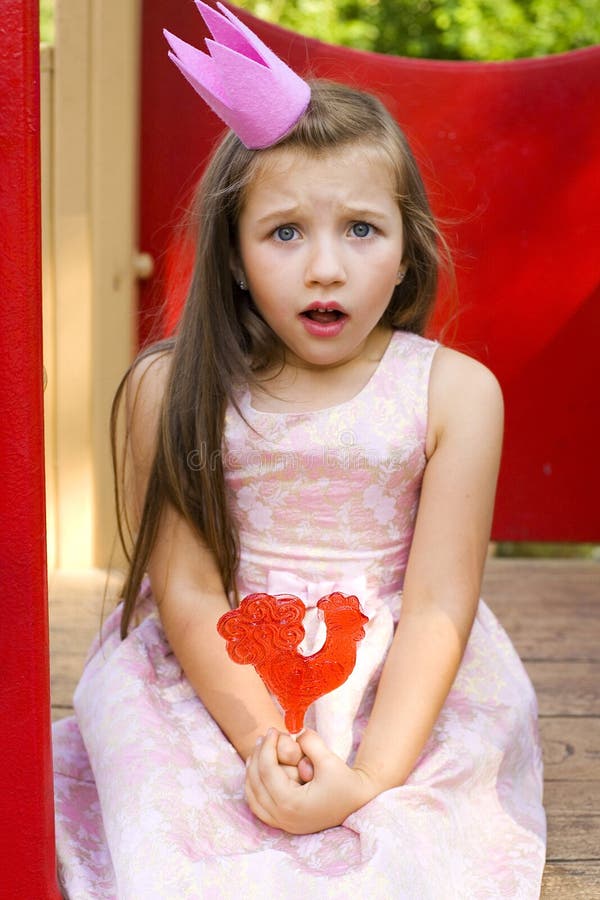 Principessa divertente e una lecca-lecca fotografie stock libere da diritti Principessa divertente e una lecca-lecca fotografie stock libere da diritti