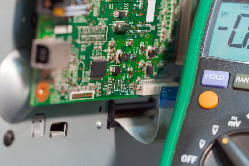 Printer Motherboard and Multimeter. Repair of Office Equipment Stock