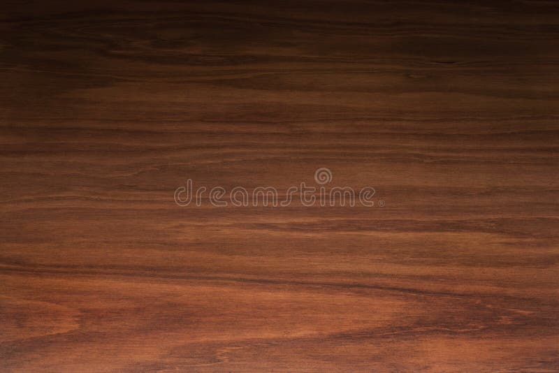 A rich dark wood background with heavy grain. Photographed from a low angle with gradated lighting from light to dark. A rich dark wood background with heavy grain. Photographed from a low angle with gradated lighting from light to dark.