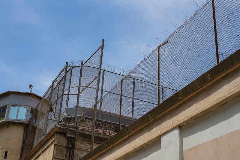 Prison wall against of blue sky, freedom concept, cell, jail, corridor, bar, penitentiary, justice, criminal, old, building, crime, interior, security, metal, prisoner, punishment, cage, iron, jailhouse, law, lock, state, block, inside, architecture, torture, convict, room, row, dark, city, historic, history, detention, imprison, incarceration, escape, federal, injury, depression, incarcerate, concrete, construction, steel, alcatraz, verdict. Prison wall against of blue sky, freedom concept, cell, jail, corridor, bar, penitentiary, justice, criminal, old, building, crime, interior, security, metal, prisoner, punishment, cage, iron, jailhouse, law, lock, state, block, inside, architecture, torture, convict, room, row, dark, city, historic, history, detention, imprison, incarceration, escape, federal, injury, depression, incarcerate, concrete, construction, steel, alcatraz, verdict