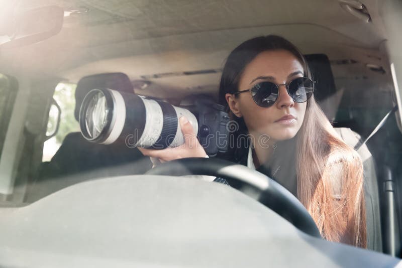 Privé-detective met camera spionage van auto stock afbeeldingen
