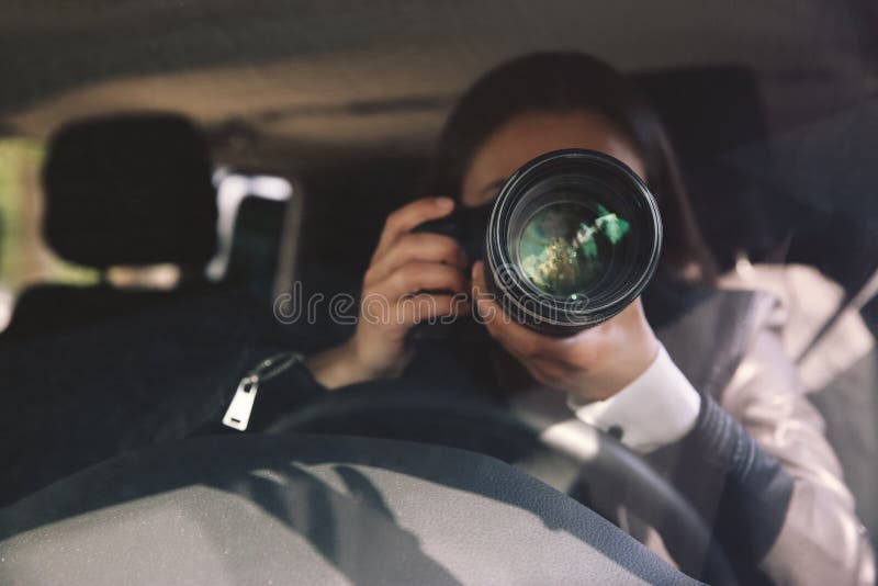 Privédetective met camera die vanuit een auto bespiedt royalty-vrije stock foto