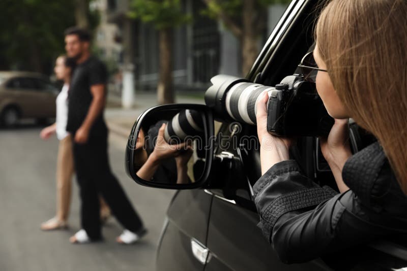 Privédetective met camera die vanuit een auto bespiedt royalty-vrije stock fotografie