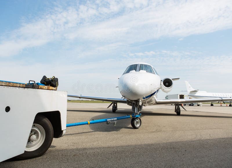 Private business jet being towed by ground crew. Private business jet being towed by ground crew