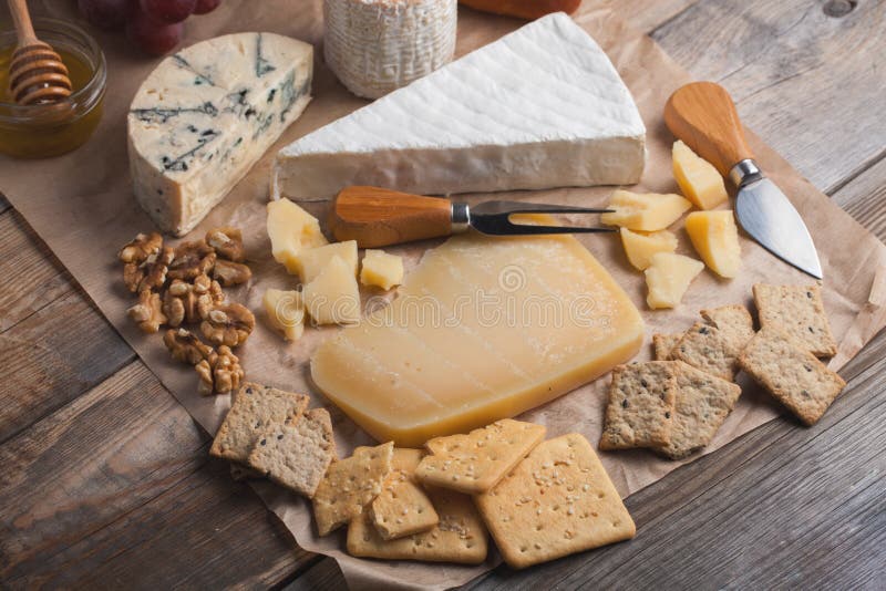 Probierenkäseteller auf einer hölzernen Platte Lebensmittel für Wein und romantisches, Käsedelikatessen auf einer hölzernen rusti lizenzfreie stockbilder Probierenkäseteller auf einer hölzernen Platte Lebensmittel für Wein und romantisches, Käsedelikatessen auf einer hölzernen rusti lizenzfreie stockbilder