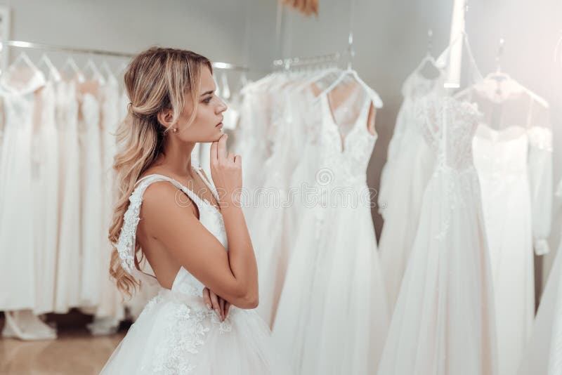 Thoughtful young woman choosing her wedding dress. stock photos Thoughtful young woman choosing her wedding dress. stock photos