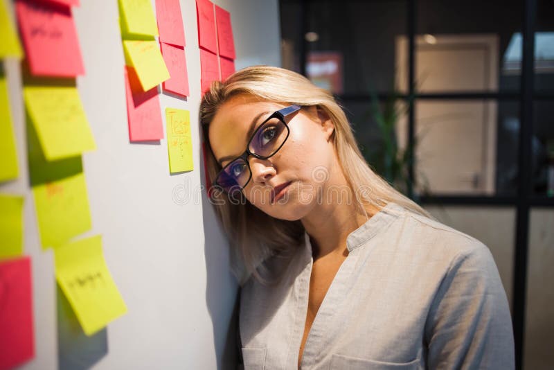 Problems on a large project, project management methodology agile and scrum concept. A tired businesswoman at the blackboard with colored sticky notes. Software methodology stock images, royalty-free photos and pictures