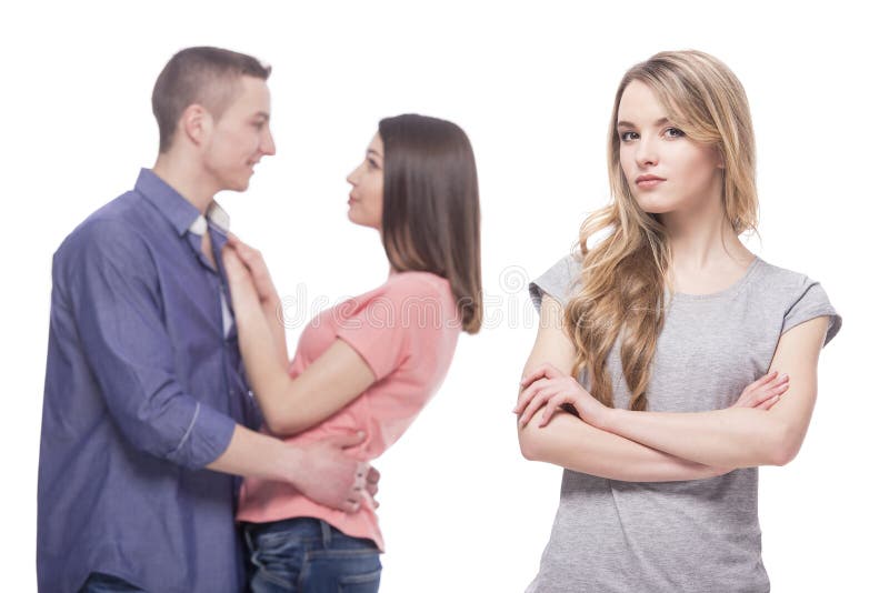 Love triangle. Loneliness. Young sad women standing with her arms crossed while another women and men hugging. isolated on white background. Love triangle. Loneliness. Young sad women standing with her arms crossed while another women and men hugging. isolated on white background.