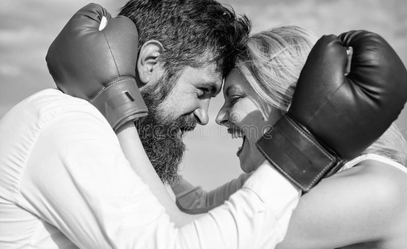 Family life happiness and relation problems. Reconciliation and compromise. Fight for your happiness. Man beard and girl cuddle happy after fight. Couple in love boxing gloves hug blue sky background. Family life happiness and relation problems. Reconciliation and compromise. Fight for your happiness. Man beard and girl cuddle happy after fight. Couple in love boxing gloves hug blue sky background.