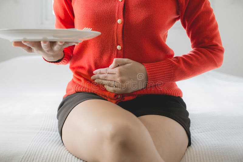 Problèmes de digestion, femme avec douleur abdominale après consommation, femelle de main tenant son ventre photographie stock libre de droits Problèmes de digestion, femme avec douleur abdominale après consommation, femelle de main tenant son ventre photographie stock libre de droits