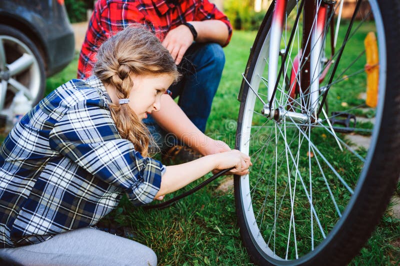 Problèmes de fixation de père et de fille avec la bicyclette extérieure en été photo stock Problèmes de fixation de père et de fille avec la bicyclette extérieure en été photo stock