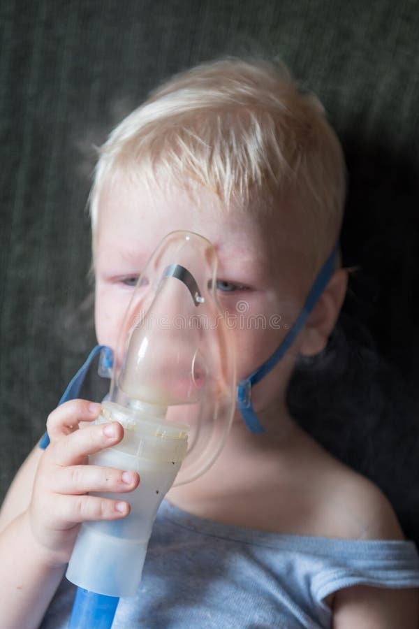 Procedimientos médicos inhalador El blonde caucásico inhala los pares que contienen la medicación para parar el toser El concepto imagen de archivo Procedimientos médicos inhalador El blonde caucásico inhala los pares que contienen la medicación para parar el toser El concepto imagen de archivo
