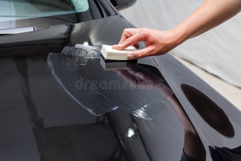 Proces stosować ceramicznego narzut na samochodu kapiszonie męskim pracownikiem z specjalnym chemicznym składem i gąbką