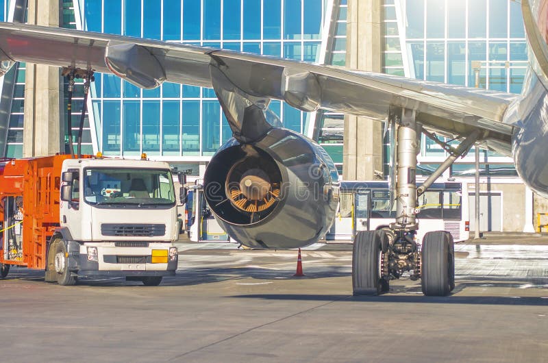 Proces van vliegtuigen het bijtanken Weergeven van de vrachtwagen, de motorvleugel en de chassis stock afbeeldingen Proces van vliegtuigen het bijtanken Weergeven van de vrachtwagen, de motorvleugel en de chassis stock afbeeldingen