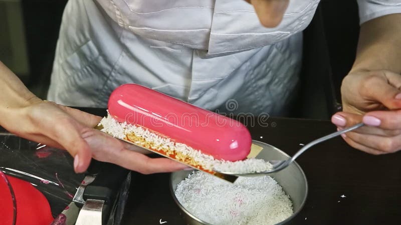 Proceso de decoración de tarta de mousse de crema acristalada ovalada con afeitado de coco