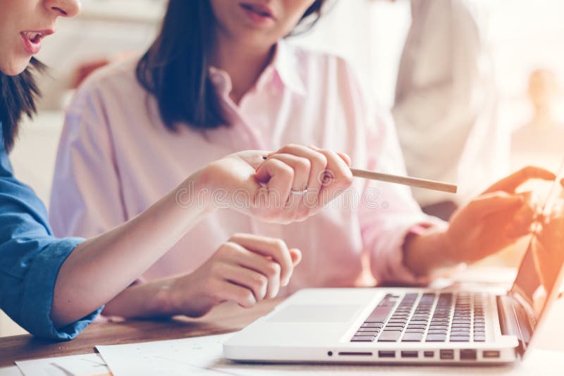Proceso del trabajo del equipo Dos mujeres con el ordenador portátil en oficina del espacio abierto Concepto del asunto Proceso del trabajo del equipo Dos mujeres con el ordenador portátil en oficina del espacio abierto Concepto del asunto