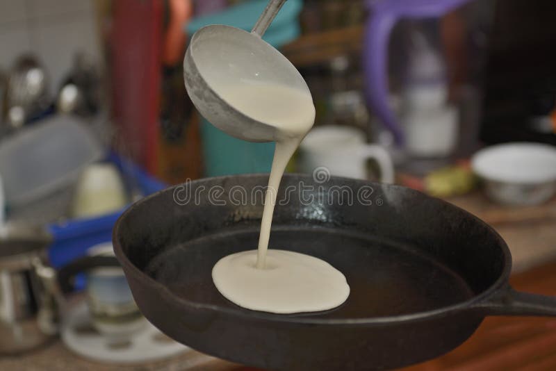 Process av bakning av pannkakan på ettjärn stekpannaslut upp arkivbilder Process av bakning av pannkakan på ettjärn stekpannaslut upp arkivbilder