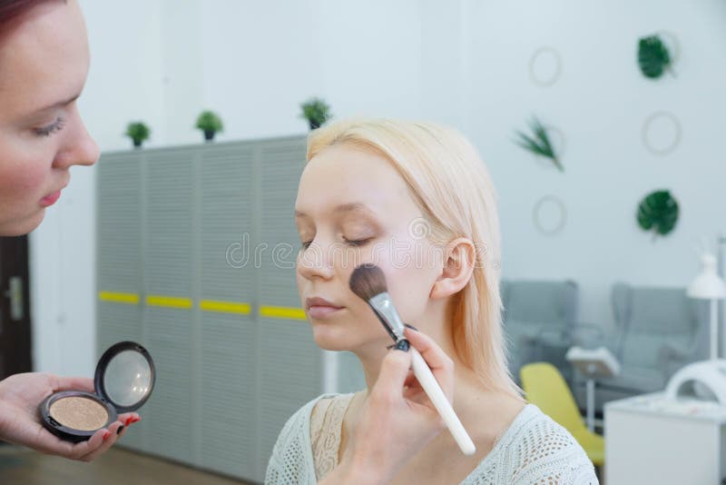 Process av danandemakeup Sminkkonstn?r som arbetar med borsten p? modellframsida arkivbild Process av danandemakeup Sminkkonstn?r som arbetar med borsten p? modellframsida arkivbild