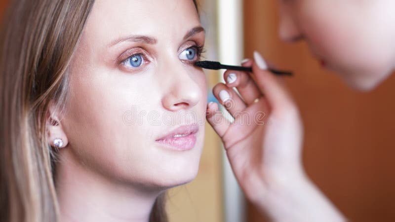 Process av danandemakeup Sminkkonstnär som arbetar med borsten på modellframsida arkivfoto Process av danandemakeup Sminkkonstnär som arbetar med borsten på modellframsida arkivfoto