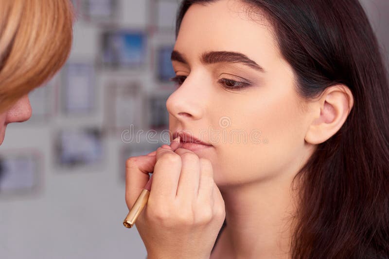 Process av danandemakeup Sminkkonstnär som arbetar med borsten på modellframsida Stående av den unga kvinnan i skönhetsalonginre arkivfoto Process av danandemakeup Sminkkonstnär som arbetar med borsten på modellframsida Stående av den unga kvinnan i skönhetsalonginre arkivfoto