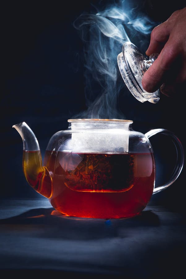 Process brewing tea,tea ceremony,Cup of freshly brewed black tea,warm soft light, darker background stock photos