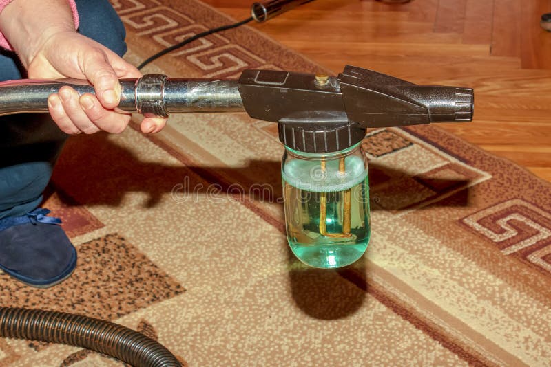 The Process of Cleaning the Carpet with a Vacuum Cleaner with a Water