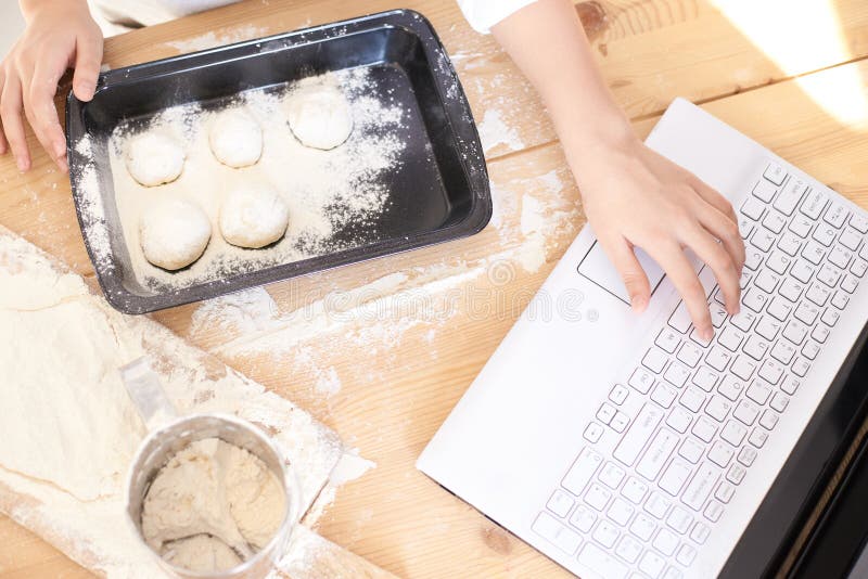 Process of cooking buns. Raw dough. White flour. Bright laptop royalty free stock photography Process of cooking buns. Raw dough. White flour. Bright laptop royalty free stock photography