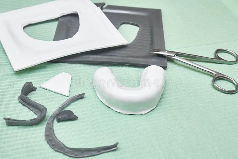 Process of Creating Custom Mouthguard. Silver Sports Mouthguard with Pieces of Plastic Material