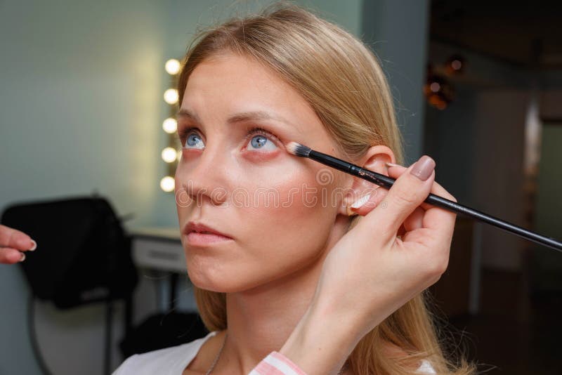 The Process of Creating Makeup. Makeup Artist Working with a Brush on