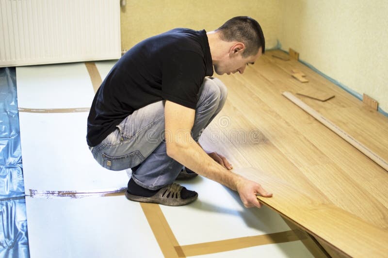 The Process of Installing Laminate Wooden on the Floor Stock Image