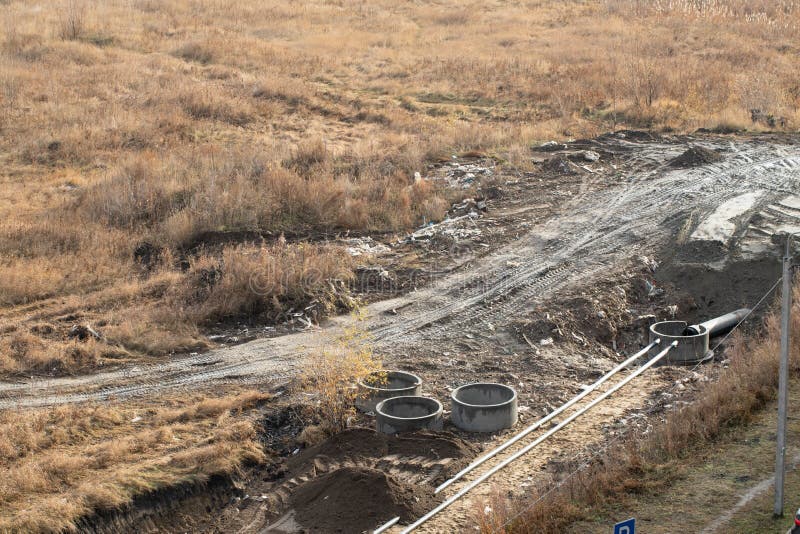 Black Plastic Pipes are in Trench of Ground. Process of Laying of